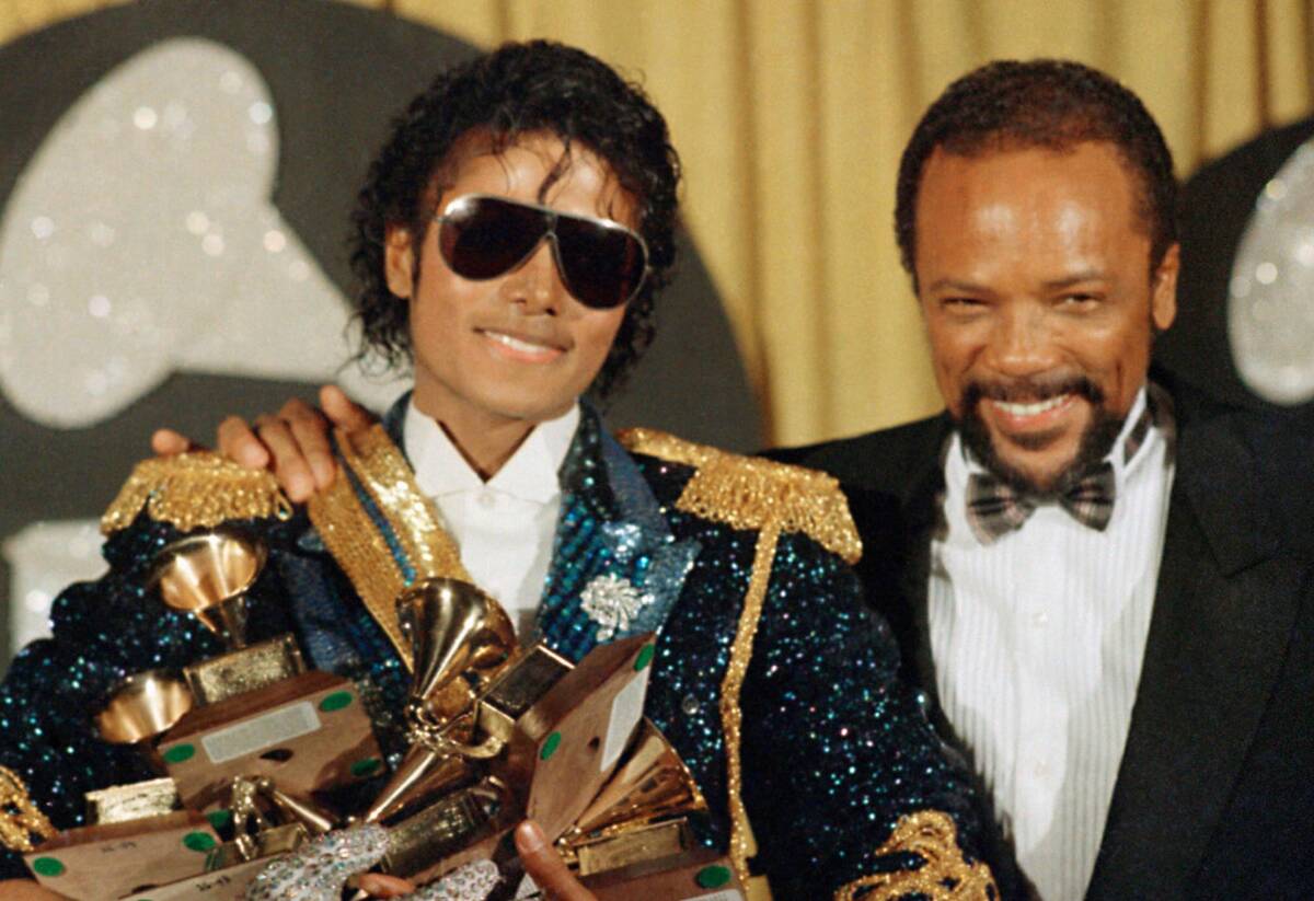 Michael Jackson, left, holds eight awards as he poses with Quincy Jones at the Grammy Awards in ...