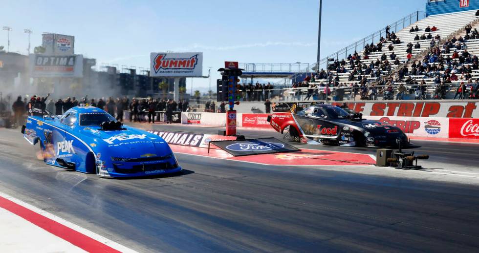 Funny car drivers Jack Beckman, left, and Paul Lee take off during the semifinals of the NHRA N ...