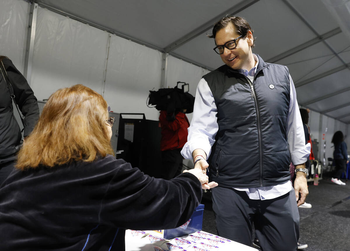 Nevada Secretary State Cisco Aguilar shakes hands with poll worker Esmeralda Reynold during pri ...