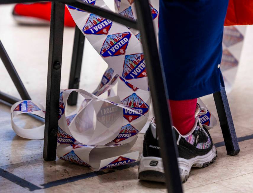 A worker readies I Voted stickers inside as people wait in line up to two hours to cast their b ...