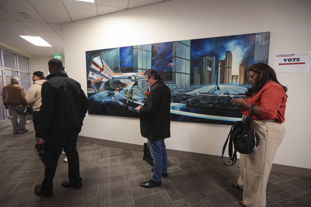 People wait in line to vote next the “Future Las Vegas’ painting by Paul Farkas a ...