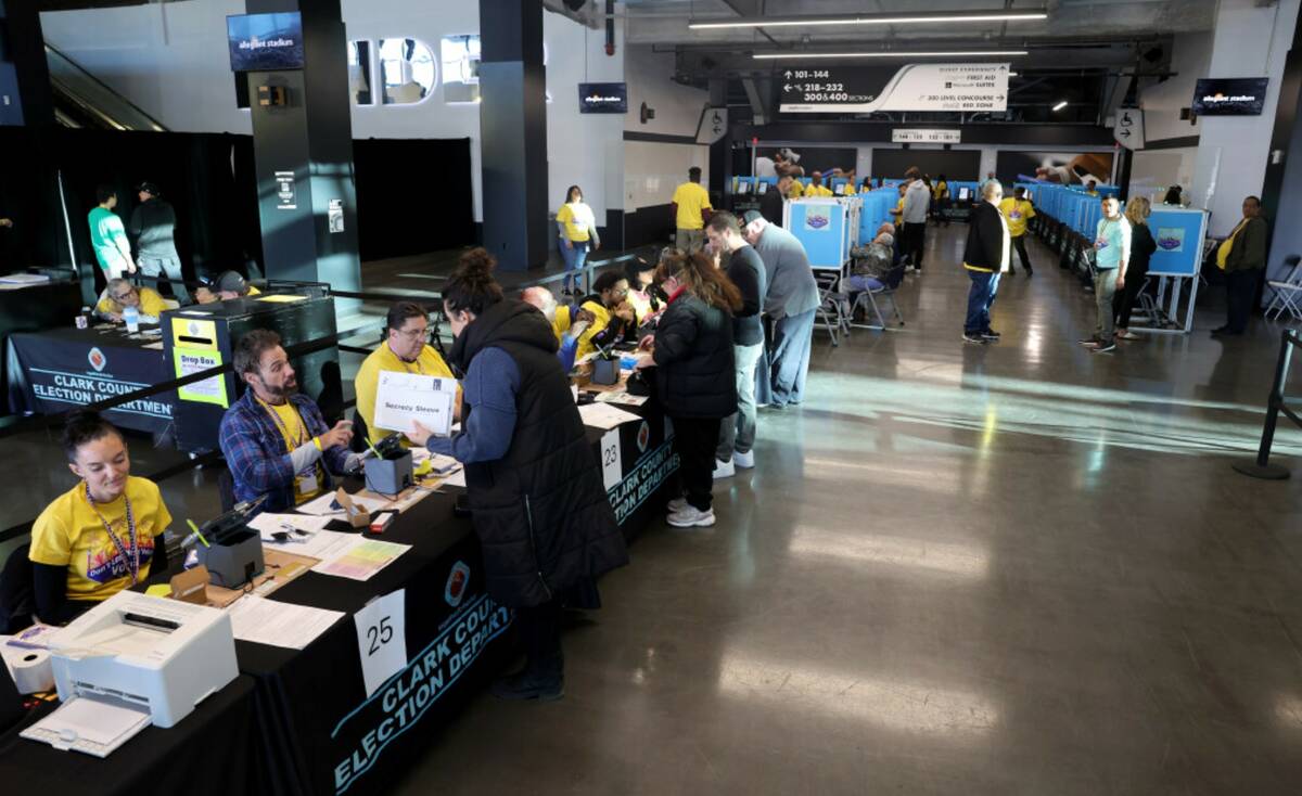 Poll workers help people check in to vote at Allegiant Stadium in Las Vegas Tuesday, Nov. 5, 20 ...