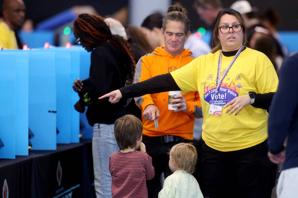 Poll workers help people cast their ballots at Allegiant Stadium in Las Vegas Tuesday, Nov. 5, ...