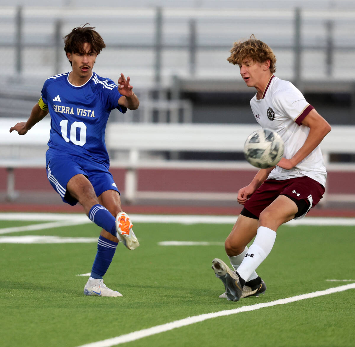 Sierra Vista forward Lazzar Ramos (10) kicks the ball past Faith Lutheran defender Aaron Berton ...