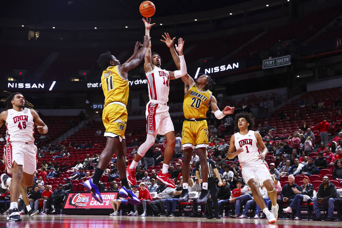 UNLV Rebels guard Jailen Bedford (14) shoots between Alabama State Hornets guards Micah Octave ...