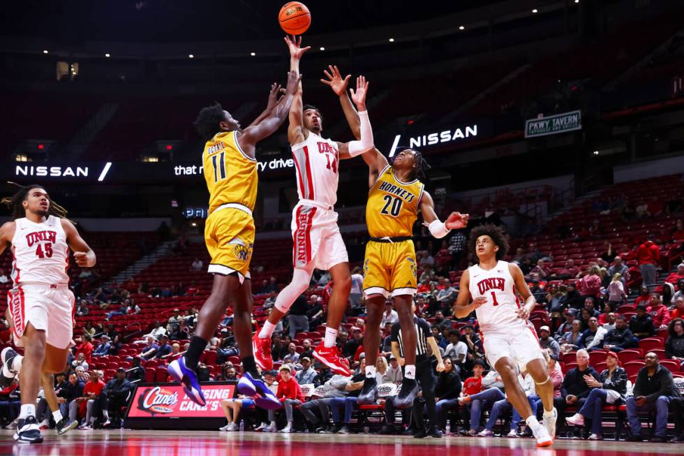 UNLV Rebels guard Jailen Bedford (14) shoots between Alabama State Hornets guards Micah Octave ...