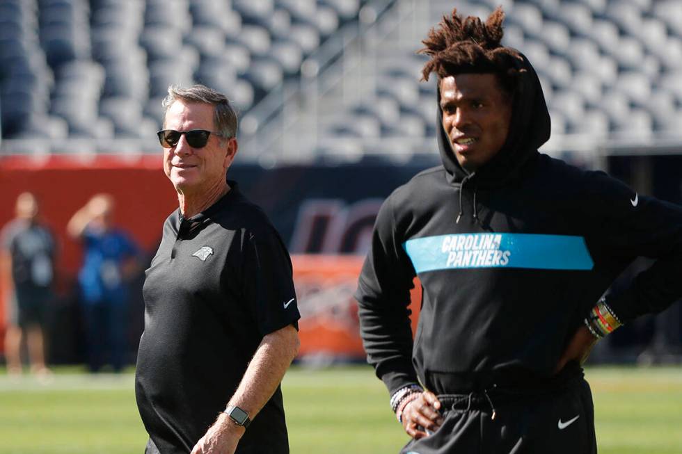 Carolina Panthers Offensive Coordinator Norv Turner, left walks behind quarterback Cam Newton b ...