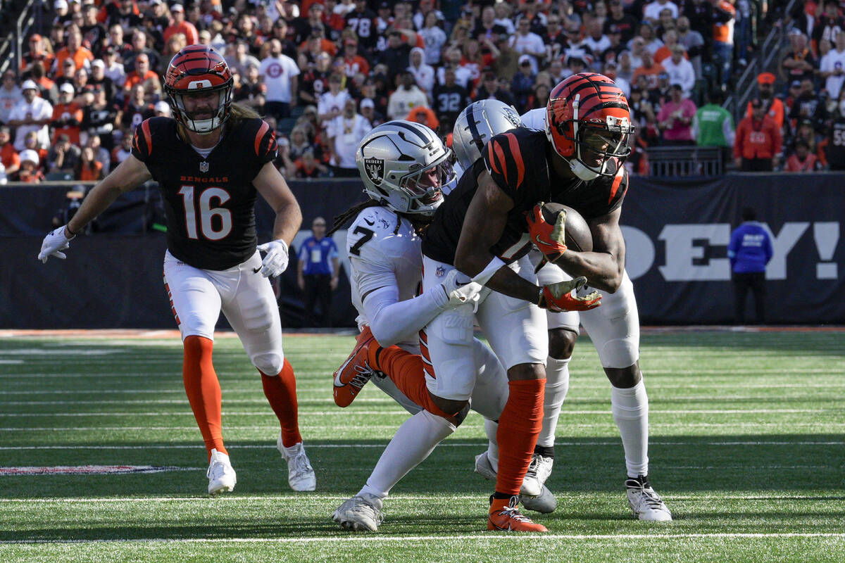 Cincinnati Bengals wide receiver Ja'Marr Chase (1) is tackled by Las Vegas Raiders safety Tre'v ...