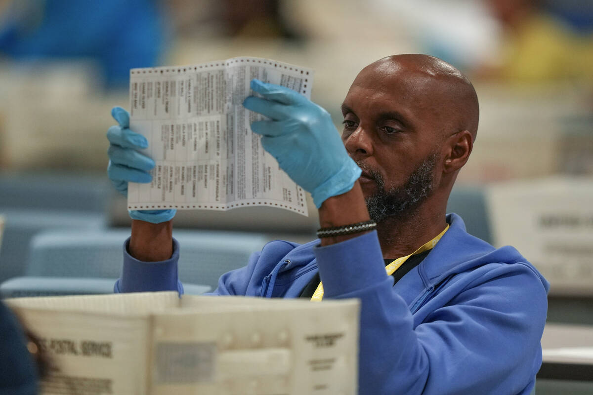 An election worker processes mail-in ballots for the 2024 General Election at the Philadelphia ...