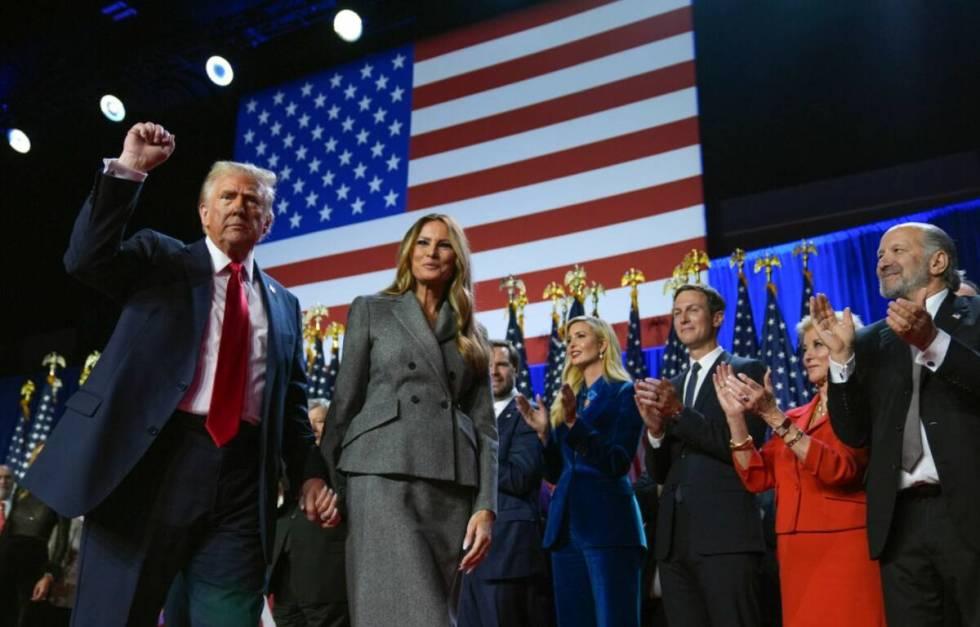 Donald Trump gestures as he walks with former first lady Melania Trump at an election night wat ...