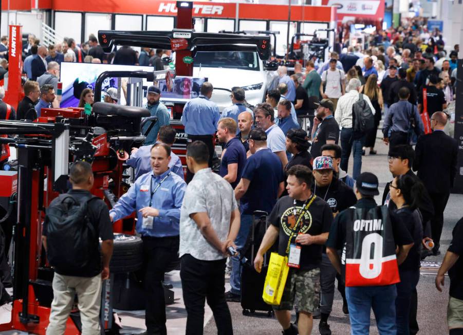 Attendees walk about and view some of the many vehicle maintenance machines by the Hunter Engin ...