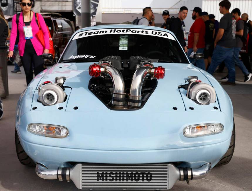 Attendees check out a custom built Mazda Miata during the first day of SEMA at the Las Vegas Co ...