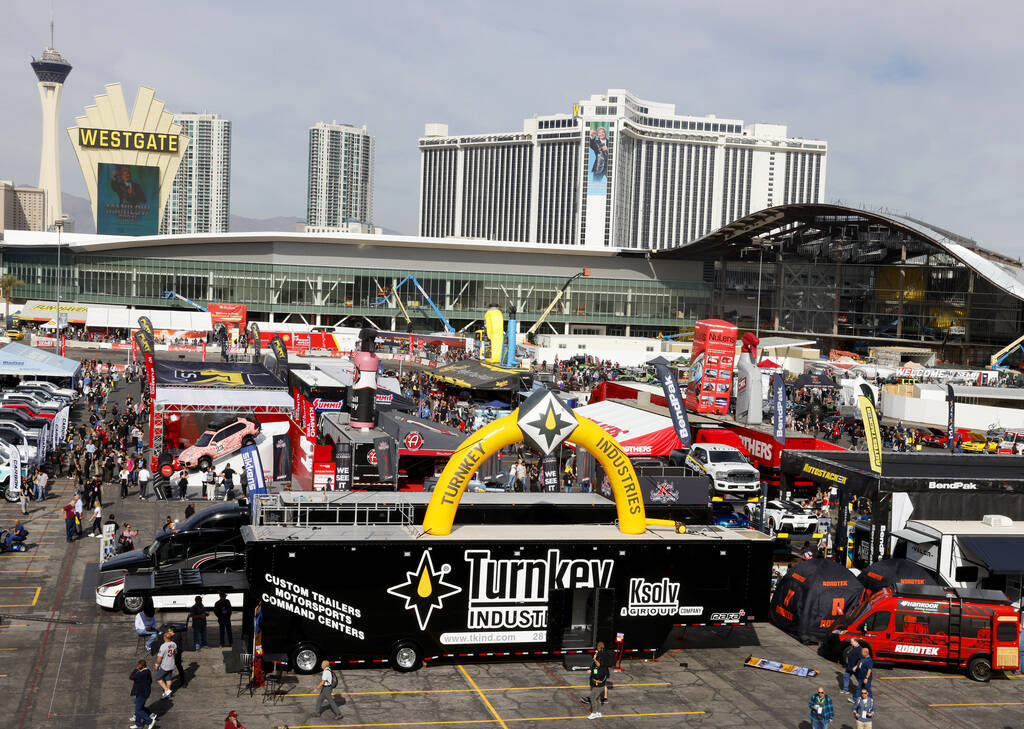 Attendees walk about and view some of the many vehicles on display during the first day of SEMA ...