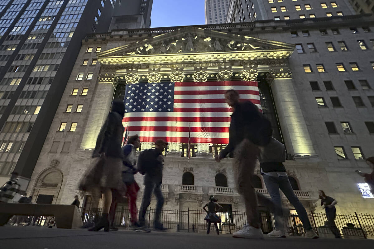 People pass the New York Stock Exchange in New York's Financial District on Tuesday, Nov. 5, 20 ...