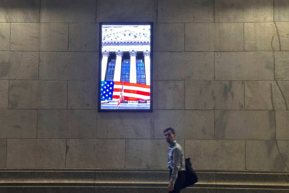 A man passes a video monitor on the side of the New York Stock Exchange in New York's Financial ...