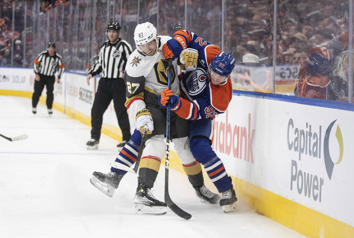 Vegas Golden Knights' Shea Theodore (27) and Edmonton Oilers' Vasily Podkolzin (92) battle for ...