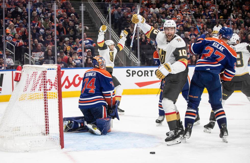 Vegas Golden Knights' William Karlsson (back left) and Nicolas Roy (10) react as the puck goes ...