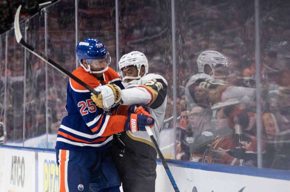 Vegas Golden Knights' Keegan Kolesar (right) is checked by Edmonton Oilers' Darnell Nurse (25) ...