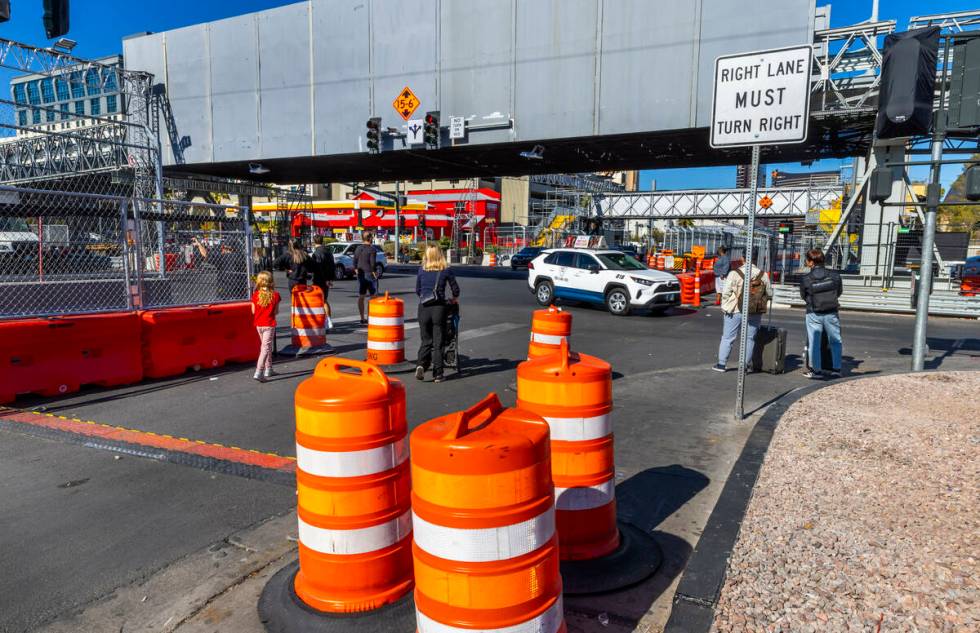 Pedestrians navigate barricades and other race barriers along Koval Lane at the Flamingo bridge ...