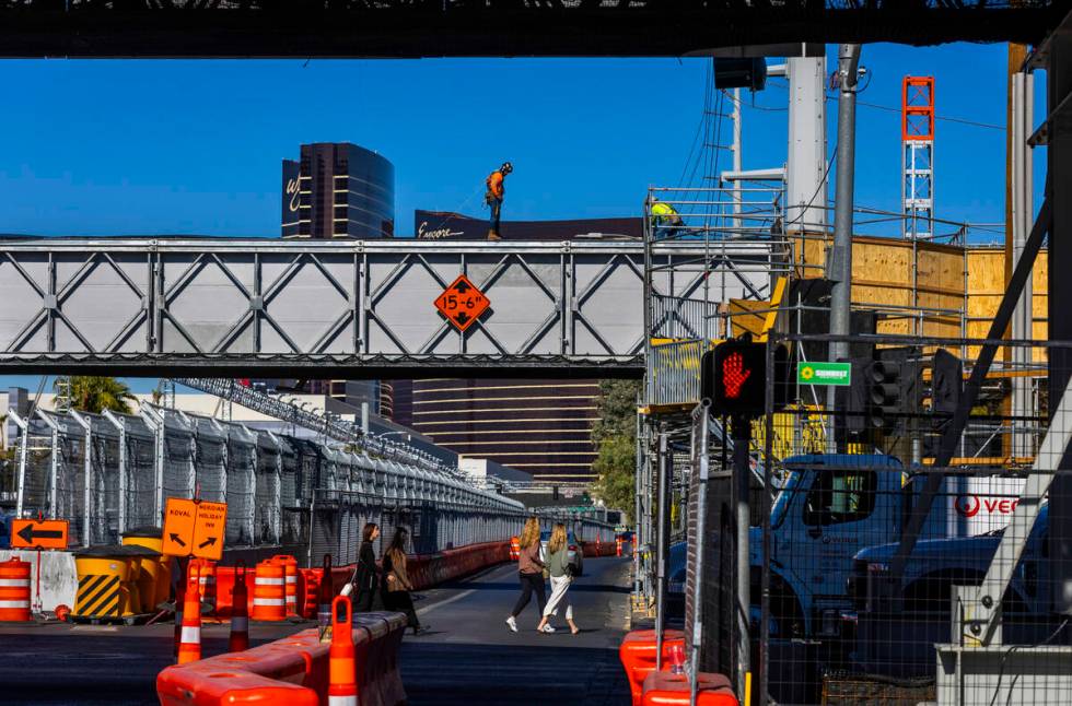 Pedestrians and traffic navigate barricades and other race barriers along Koval Lane at the Fla ...