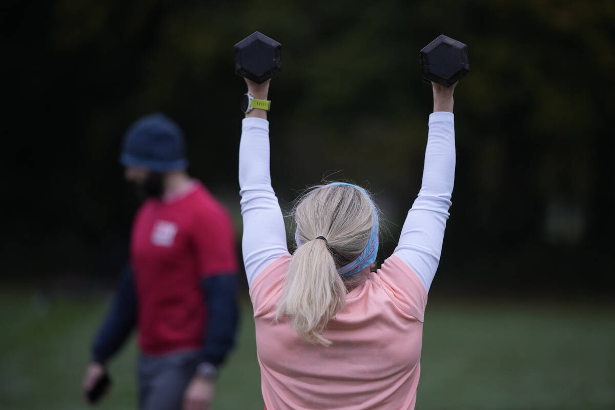 Personal fitness trainer Richard Lamb, leads a group in an outdoor gym class in London, Saturda ...