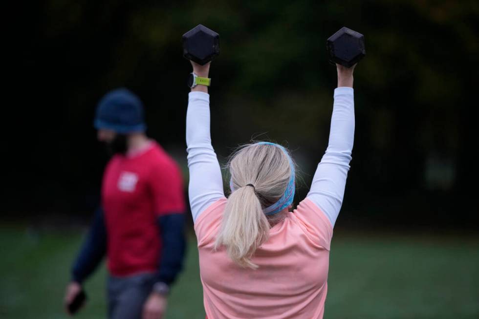 Personal fitness trainer Richard Lamb, leads a group in an outdoor gym class in London, Saturda ...