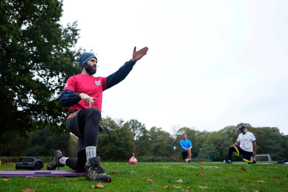 Personal fitness trainer Richard Lamb, gestures as he leads an outdoor gym class in London, Sat ...