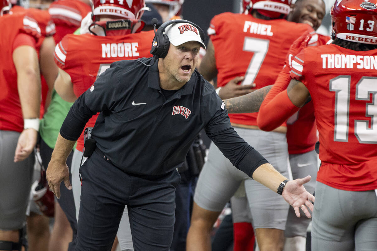 UNLV head coach Barry Odom welcomes players back to the sideline after scoring a touchdown duri ...