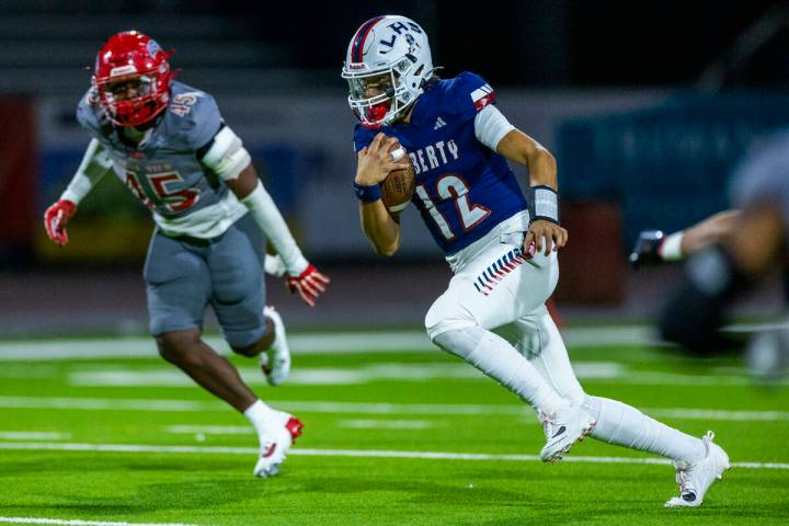 Liberty quarterback Elijah Espinoza (12) takes off on another run as Arbor View defensive linem ...