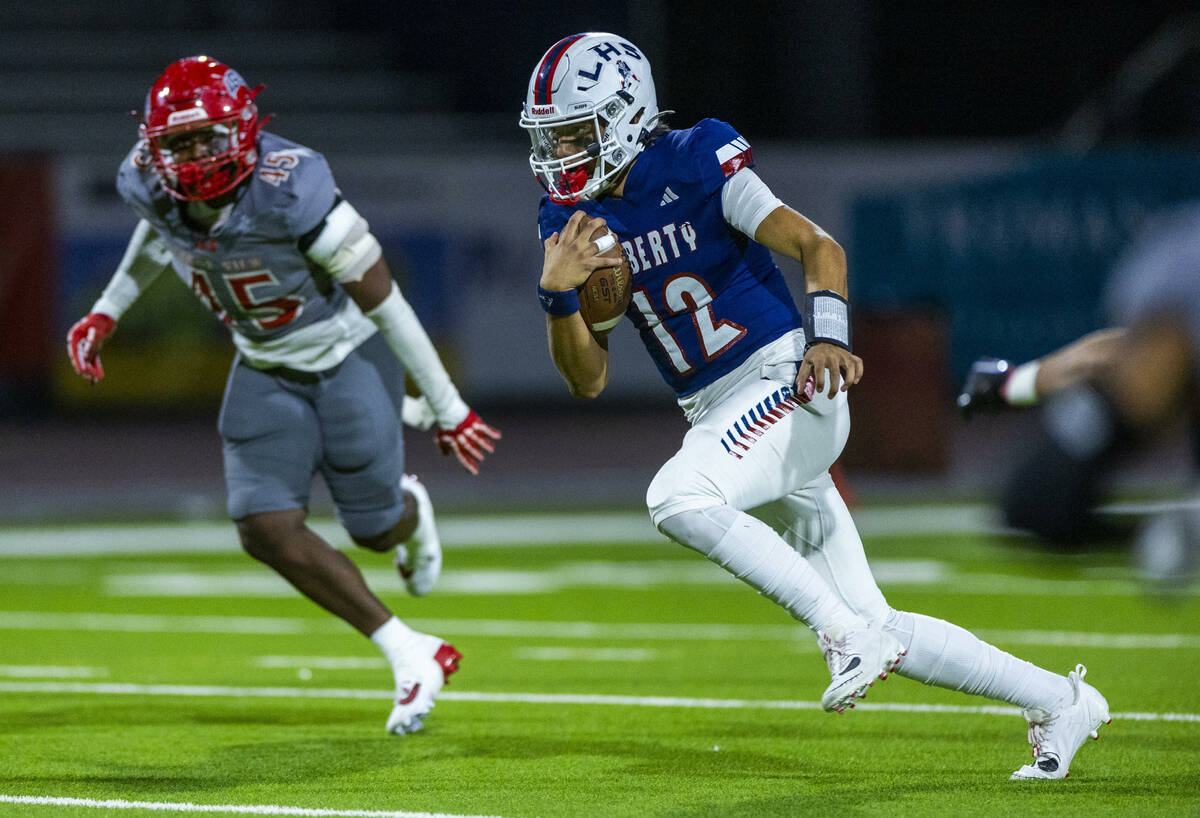 Liberty quarterback Elijah Espinoza (12) takes off on another run as Arbor View defensive linem ...