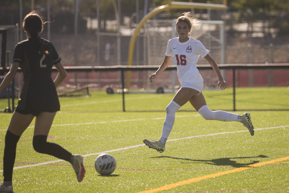 Coronado's Mia Schlachter (16) and Faith Lutheran's Elliott Lujuan (2) eye the ball during a so ...