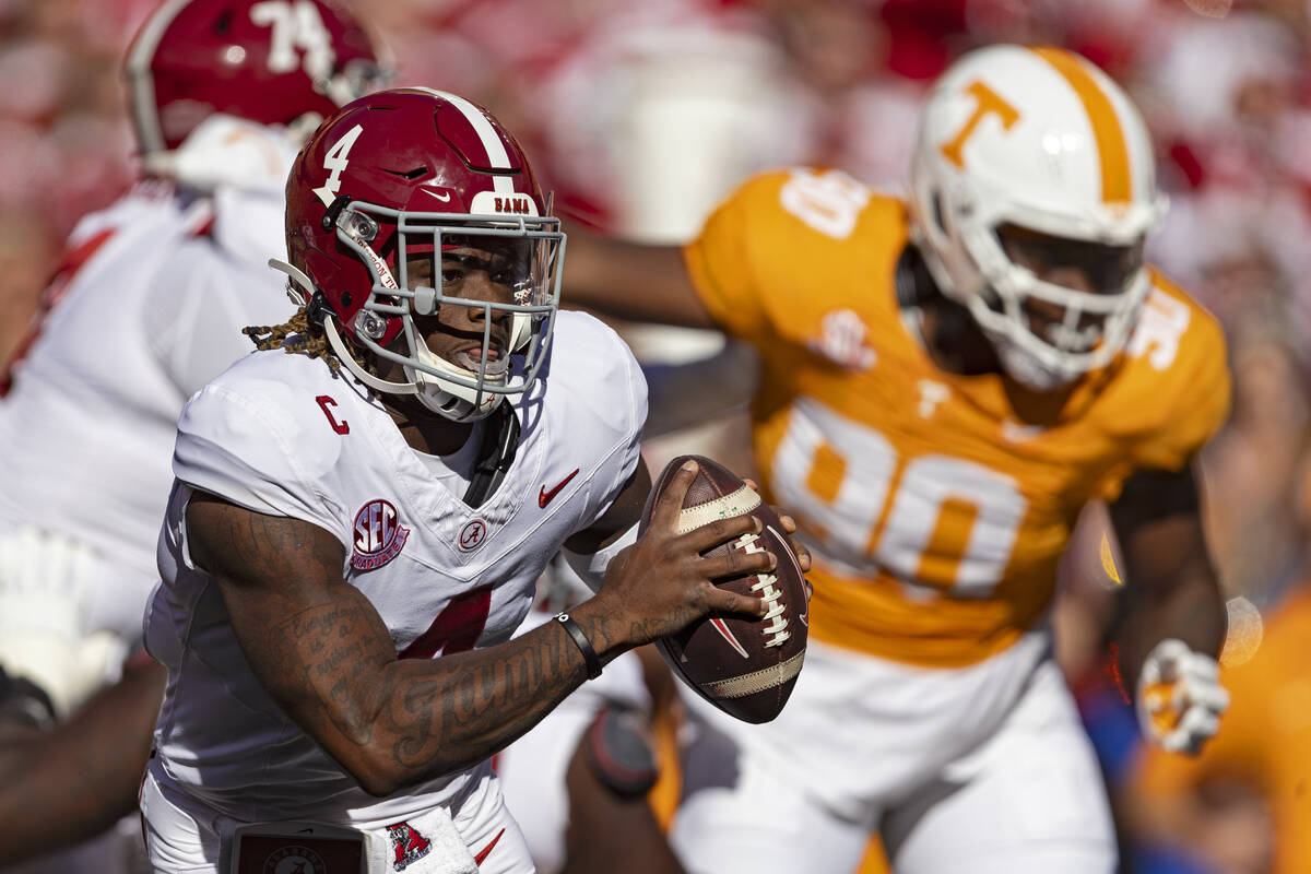 Alabama quarterback Jalen Milroe (4) rolls out to pass during the first half of an NCAA college ...