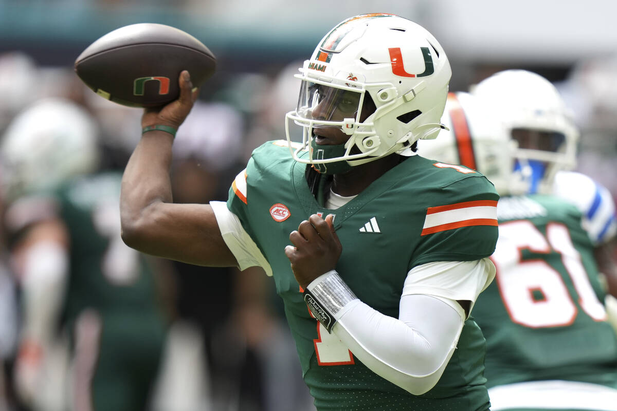 Miami quarterback Cam Ward (1) throws a pass during the first half of an NCAA college football ...