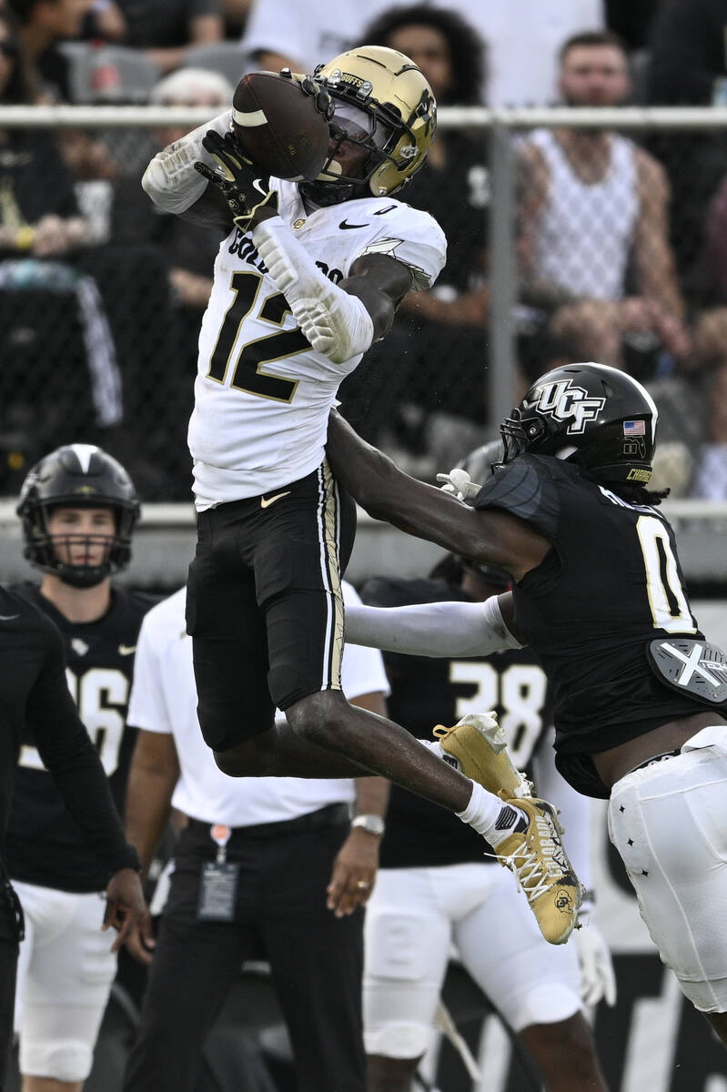 Colorado wide receiver Travis Hunter (12) catches a pass as Central Florida defensive back Bran ...