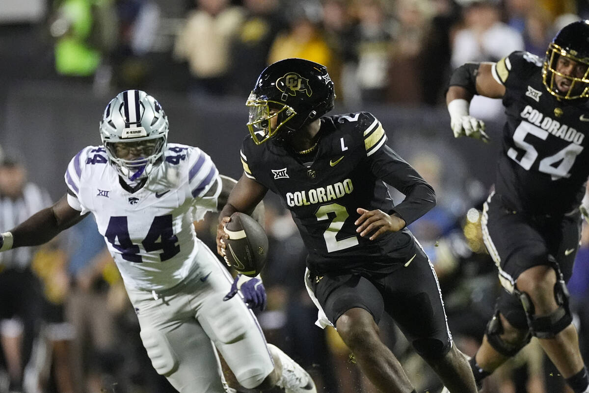 Colorado quarterback Shedeur Sanders (2) eludes Kansas State defensive end Tobi Osunsanmi (44) ...