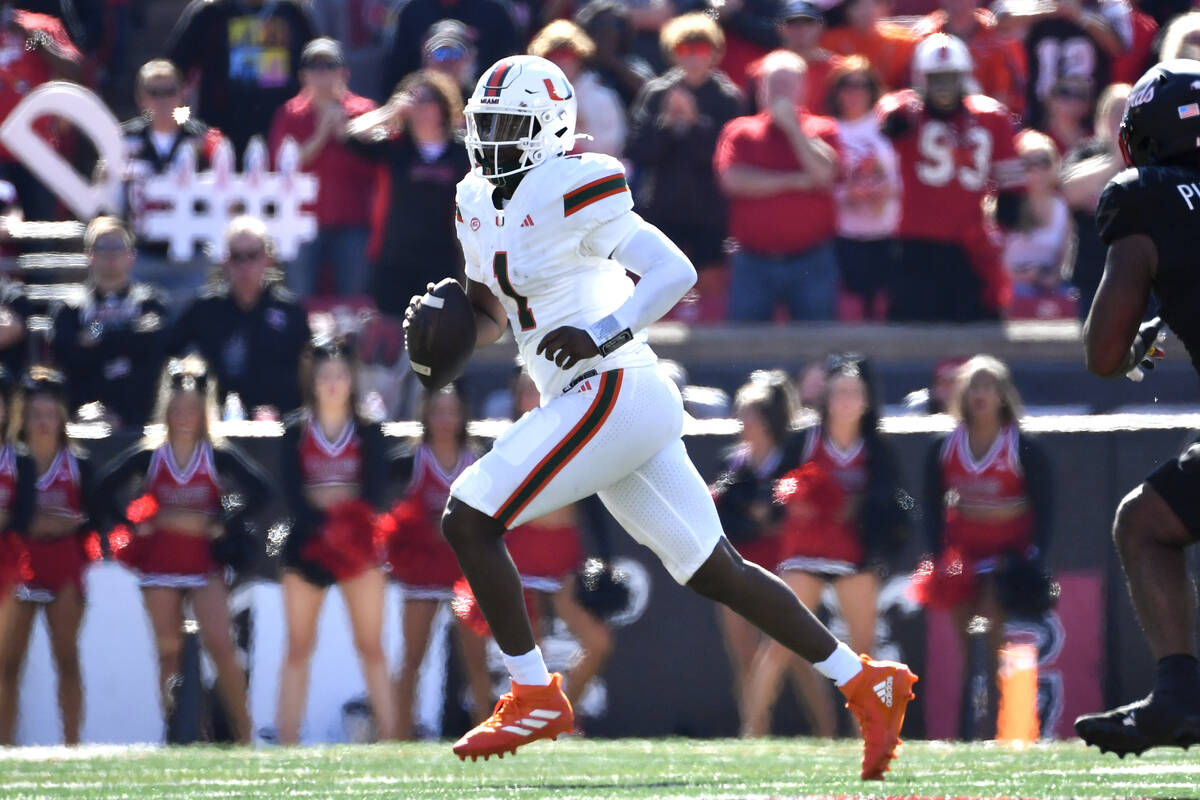 Miami quarterback Cam Ward (1) scrambles for a first down during the first half of an NCAA coll ...