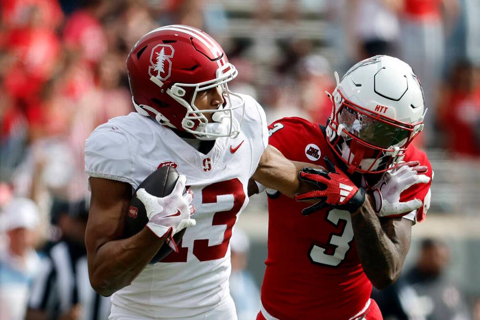 Stanford wide receiver Elic Ayomanor (13) stiff-arms North Carolina State cornerback Aydan Whit ...