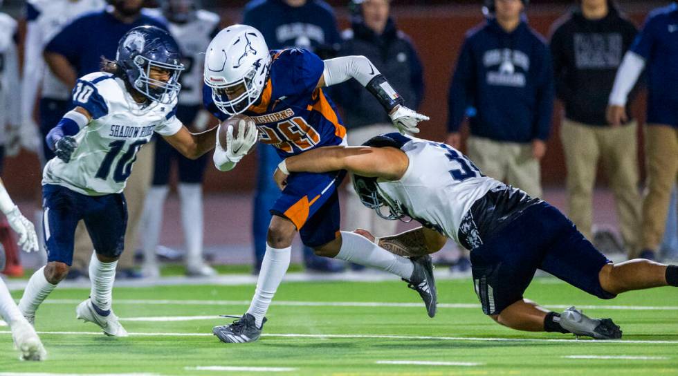 Legacy halfback Cameron Turner (29) is tackled by Shadow Ridge linebacker Jairus Howard (36) du ...