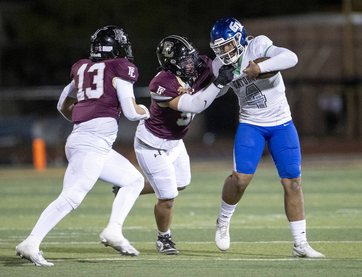 Green Valley quarterback Ben Parker (4) is sacked by Faith Lutheran sophomore Joel Sandoval, le ...