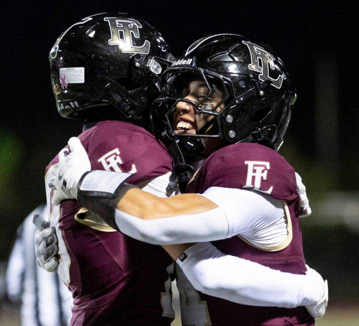 Faith Lutheran junior Rouselle Shepard, right, and senior Jaxon Cope, left, celebrate a touchdo ...