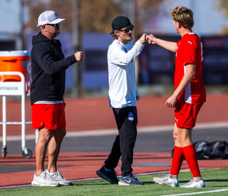 Coronado head coach Dustin Barton greets Coronado defender Ben Aronow (15) as he leaves the fie ...