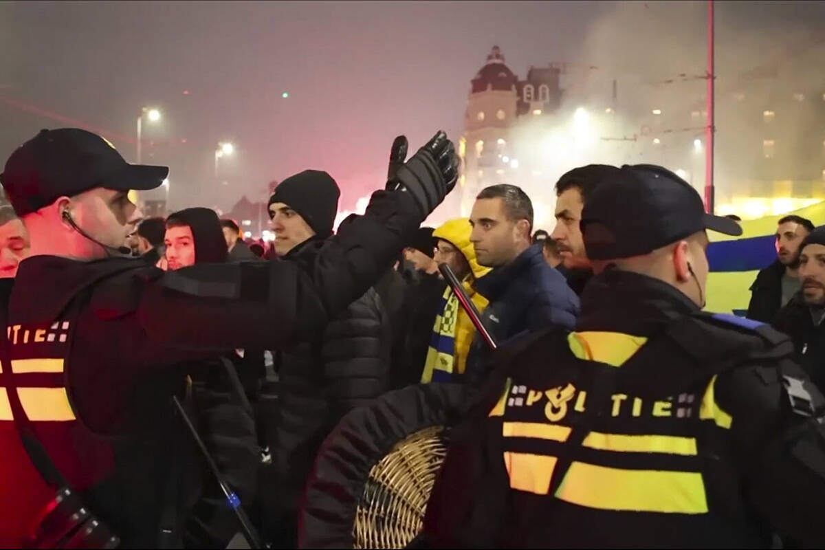 In this image taken from video, police escort Maccabi Tel Aviv supporters to the metro station ...