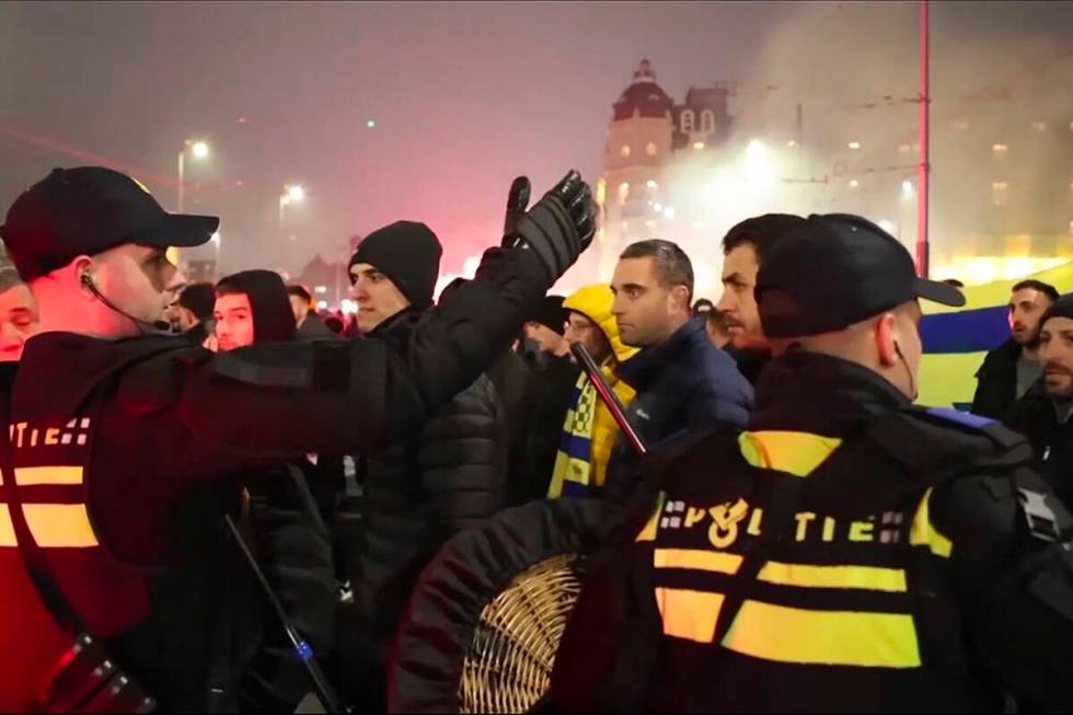 In this image taken from video, police escort Maccabi Tel Aviv supporters to the metro station ...