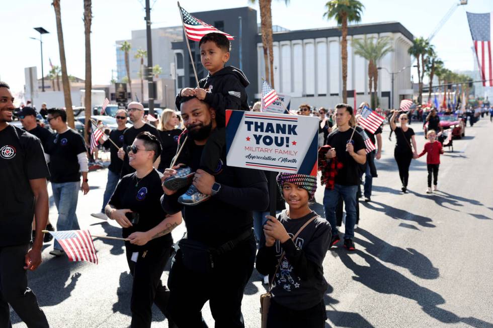 Military families with Caesars Entertainment march during the Las Vegas Veterans Day Parade dow ...