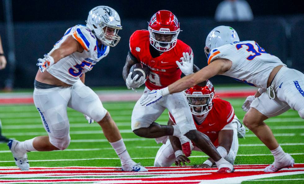 UNLV running back Jai'Den Thomas (9) looks to fend off Boise State Broncos safety Alexander Teu ...