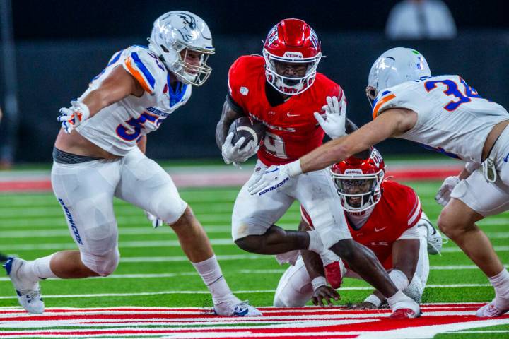 UNLV running back Jai'Den Thomas (9) looks to fend off Boise State Broncos safety Alexander Teu ...