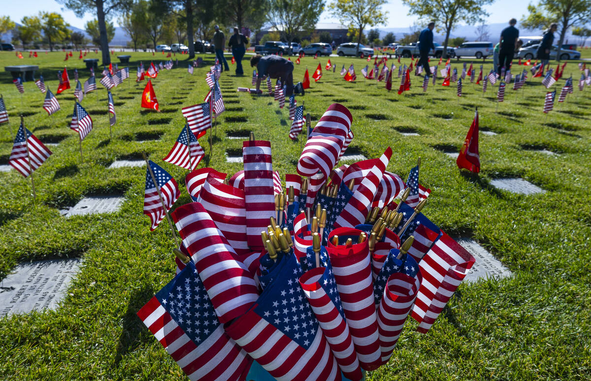 Volunteers place around 14,000 small American flags at veterans grave markers in the Southern N ...