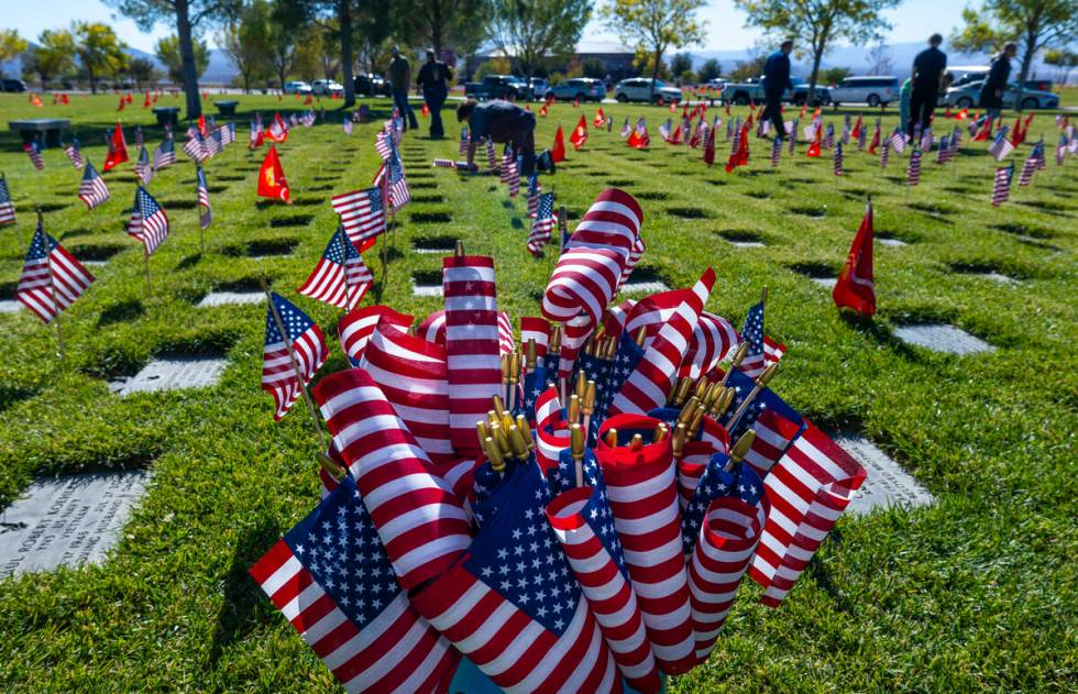 Volunteers place around 14,000 small American flags at veterans grave markers in the Southern N ...