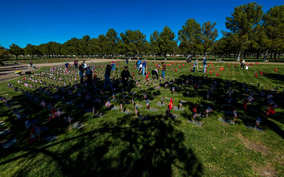 Volunteers place around 14,000 small American flags at veterans grave markers in the Southern N ...