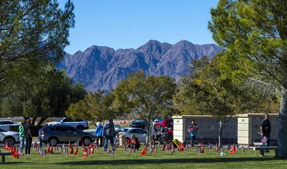 Volunteers place around 14,000 small American flags at veterans grave markers in the Southern N ...